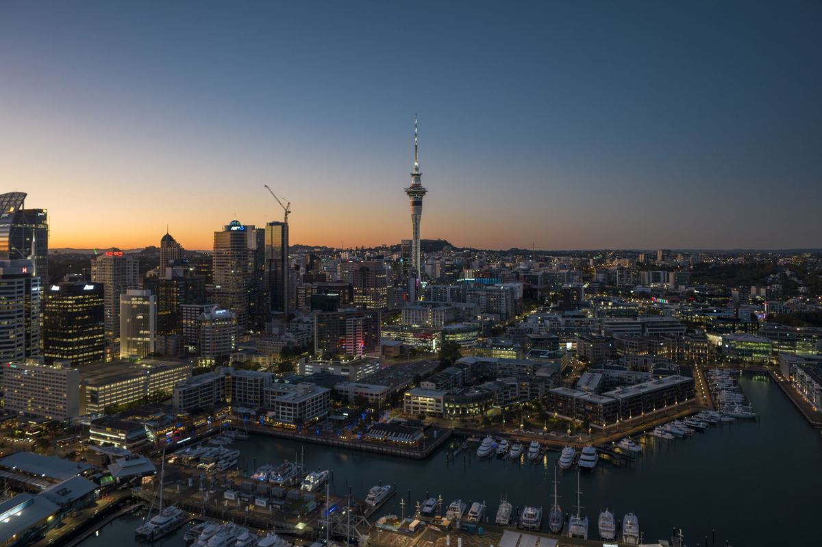 Auckland skyline and Sky Tower at sunset across the harbour